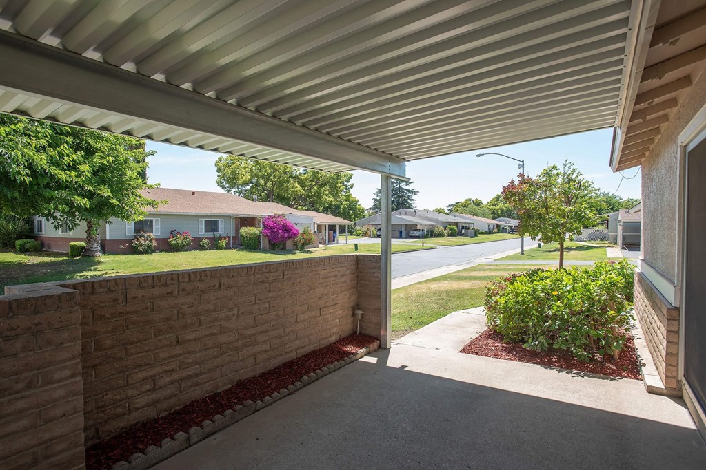 a covered porch with a view of a street and some houses at Castle Vista Senior Duplex Community, Atwater, 95301