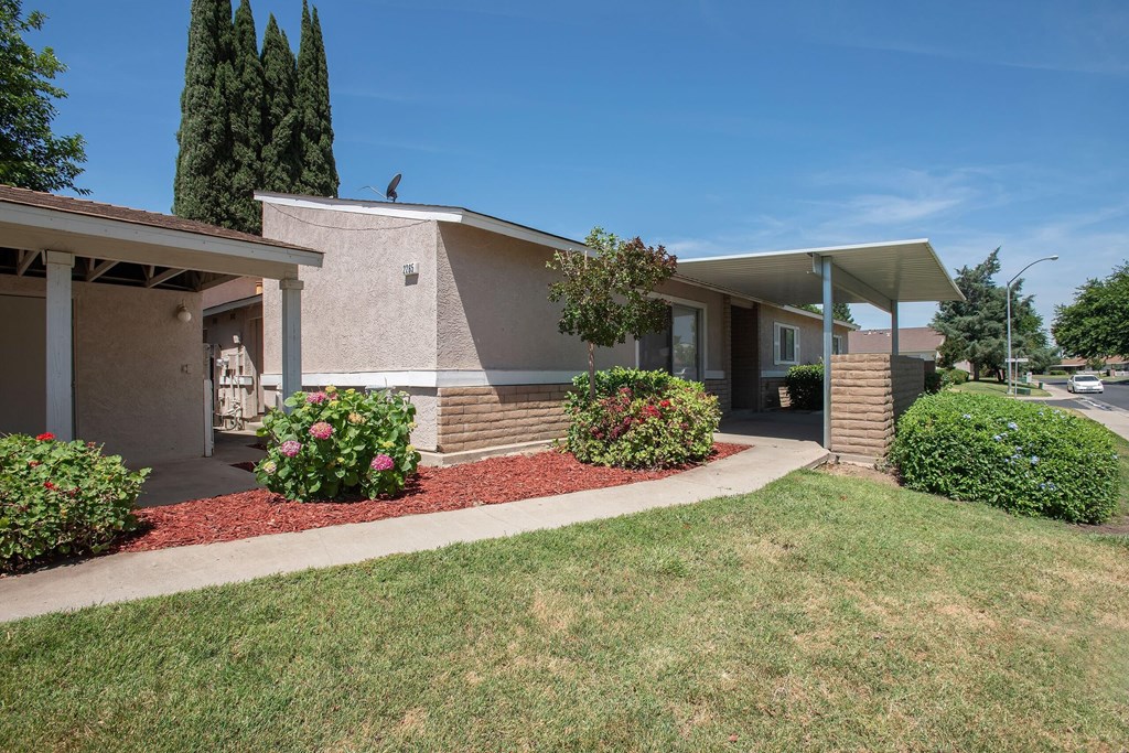 a building with a porch and a lawn in front of it at Castle Vista Senior Duplex Community, Atwater, CA, 95301