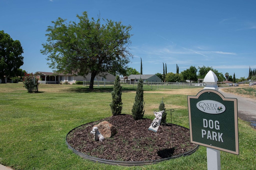 a dog park with a sign in the grass at Castle Vista Senior Duplex Community, Atwater, CA, 95301