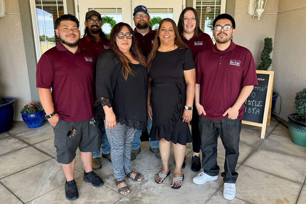 a group of people posing for a picture in front of a building at Castle Vista Senior Duplex Community, Atwater