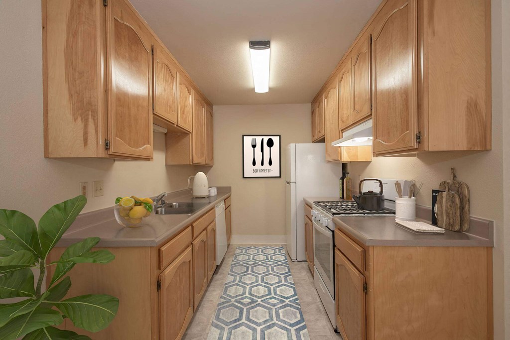 a kitchen with wooden cabinets and a white refrigerator at Castle Vista Senior Duplex Community, Atwater, CA, 95301