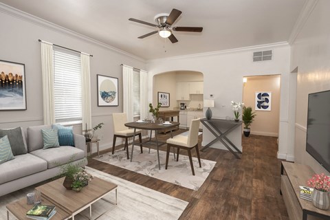 A living room with a grey couch, a wooden coffee table, and a ceiling fan.