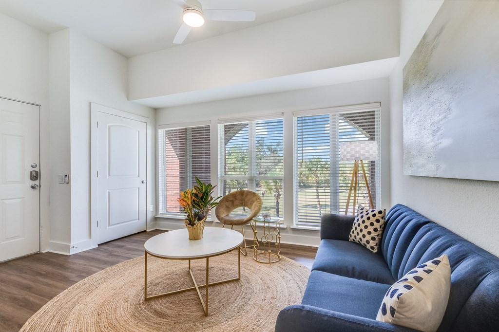 A living room with a blue couch and a round table.