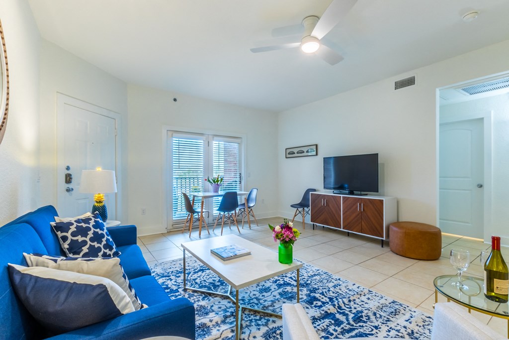 a living room with a blue couch and a coffee table and a television