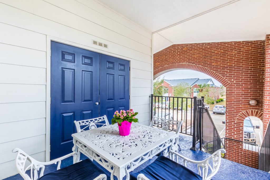 a patio with a table and chairs and a blue door