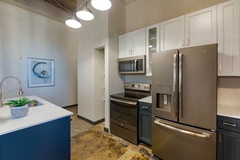 A kitchen with a blue counter and stainless steel appliances.