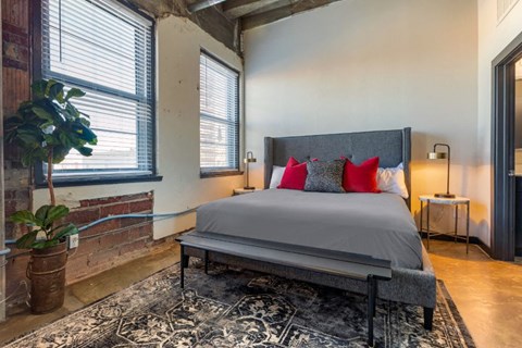 Industrial Style Apartment Bedroom with Windows, Bed, Nightstand and Plants