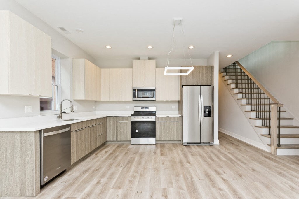 a kitchen with a stainless steel refrigerator and a sink