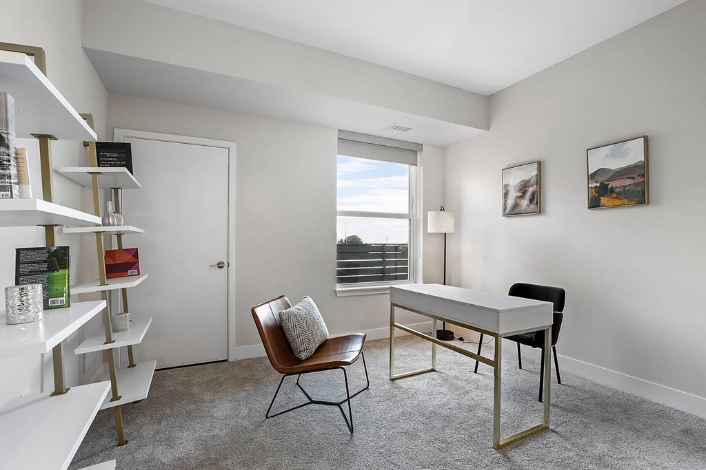 a home office with a desk and a window