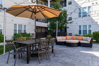 a patio with a table and chairs and an umbrella
