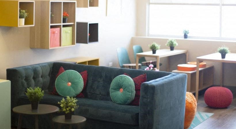 a living room with a blue couch and tables