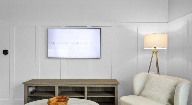 a living room with a chair and a tv on the wall