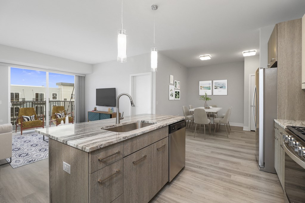 a kitchen with an island and a living room with a dining room and a television