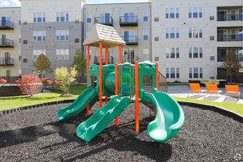 a playground with slides at an apartment complex