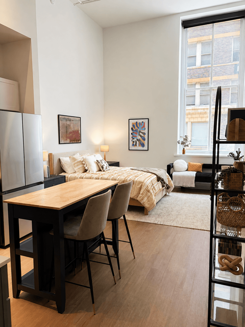 A modern bedroom with a large bed and a wooden table.