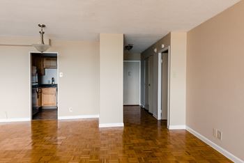 an empty living room with a hard wood floor and white walls at Hampton Plaza Apartments, Towson, Maryland