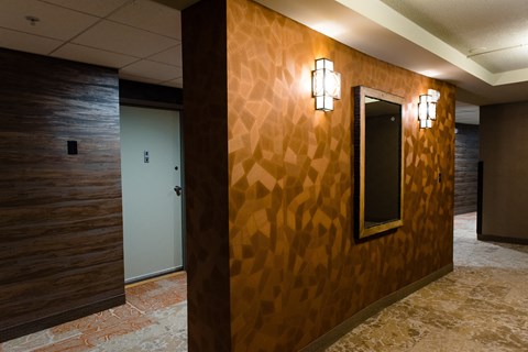 the hallway of a with a mirror on the wall at Hampton Plaza Apartments, Towson, MD