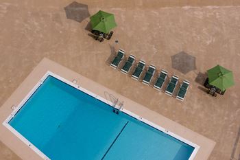 an aerial view of a swimming pool with green umbrellas and chairs at Hampton Plaza Apartments, Maryland, 21286