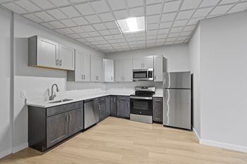 A kitchen with a refrigerator, oven, and sink at Hampton Plaza Apartments, Towson