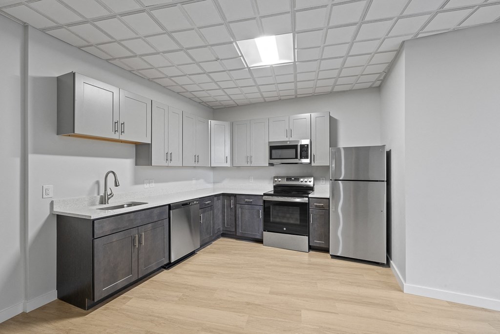 A kitchen with a refrigerator, oven, and sink at Hampton Plaza Apartments, Towson, MD, 21286