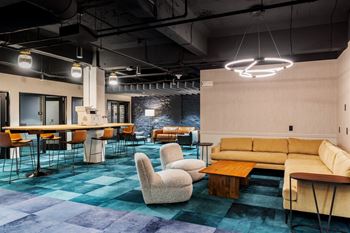 a lobby with couches chairs and tables and a bar at Textile Apartments, Cincinnati, 45202