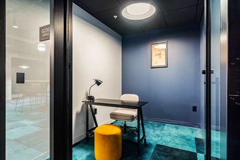 a desk with a chair and a lamp in a room with a door at Textile Apartments, Cincinnati, OH
