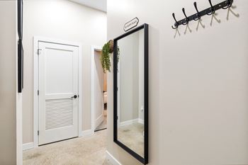 a mirror in a hallway with a closet and a door to a bathroom at Textile Apartments, Cincinnati