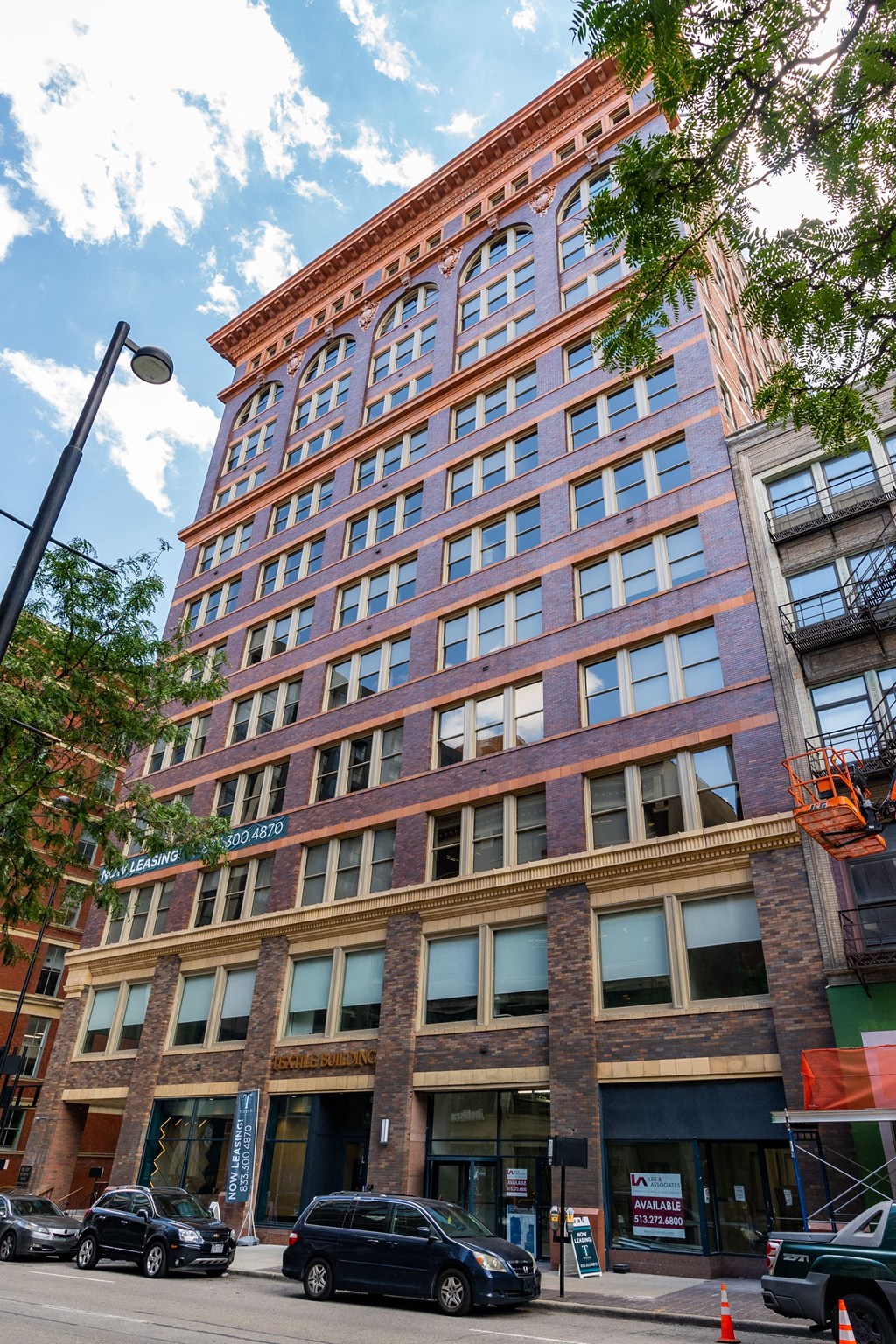 a tall brick building with cars parked in front of it at Textile Apartments, Ohio