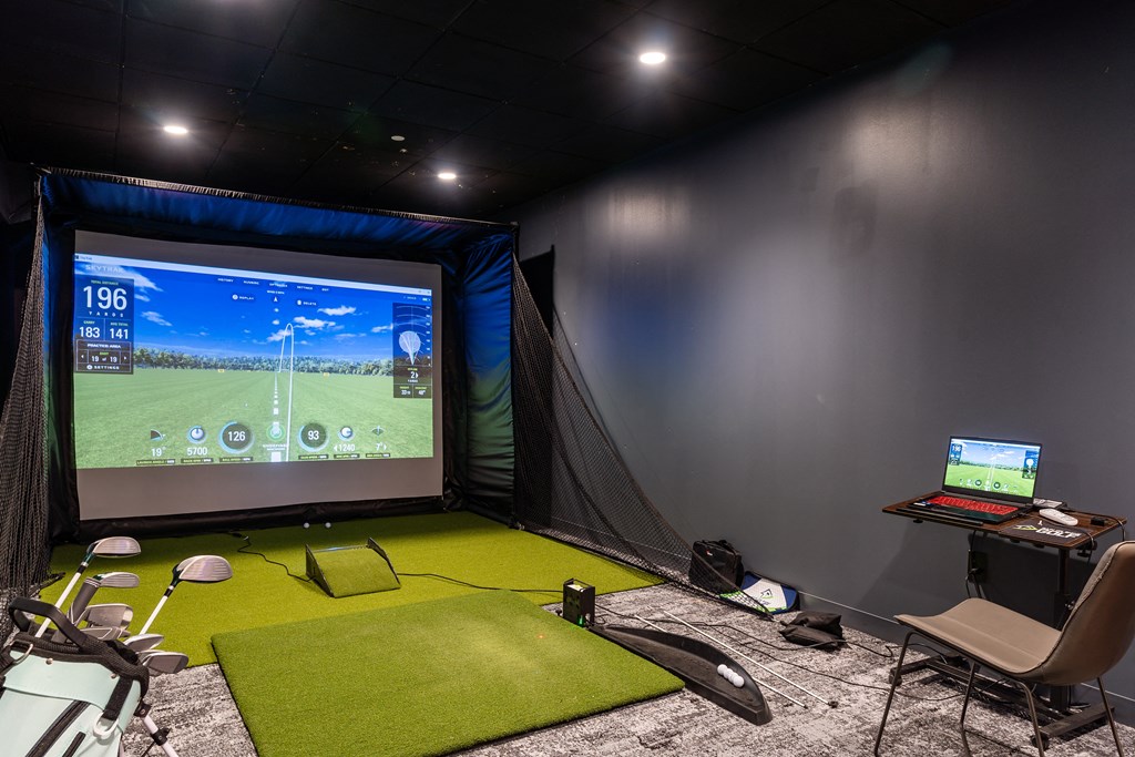 a home cinema with a screen and a green carpet floor and a desk  at Textile Apartments, Cincinnati, Ohio