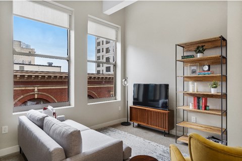 a living room with a couch and a tv and a window