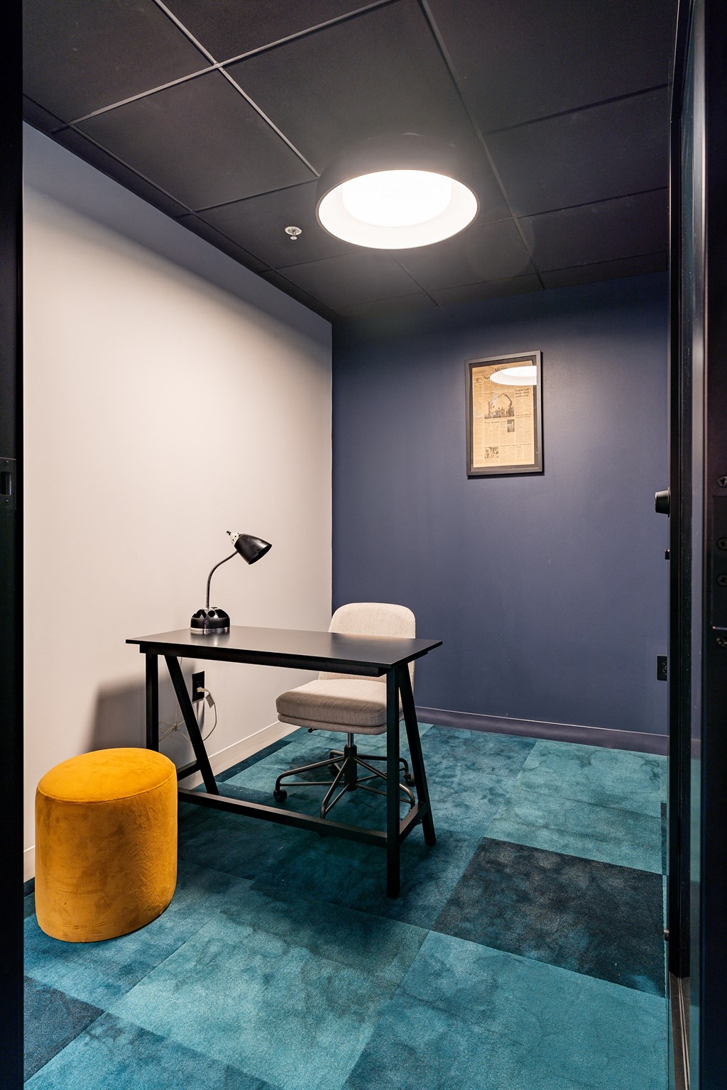 a room with a desk and a chair and a lamp at Textile Apartments, Ohio