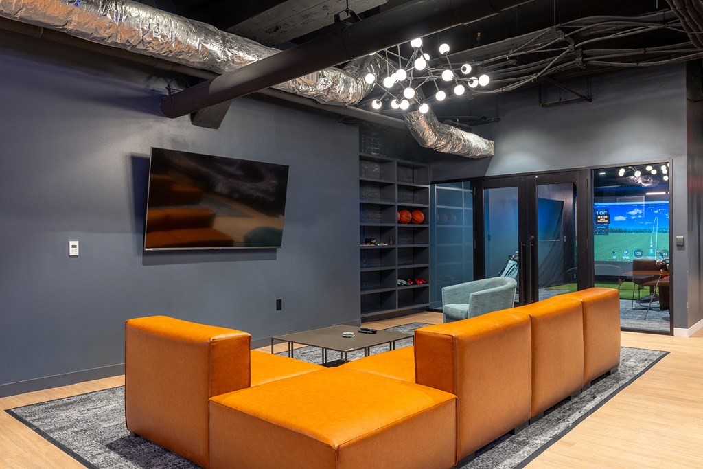 a living room with orange couches and a television at Textile Apartments, Cincinnati, 45202