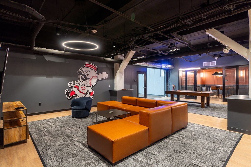 a lobby with orange couches and a mural of a baseball player at Textile Apartments, Cincinnati, OH, 45202