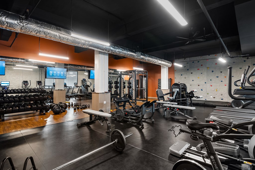 a gym with weights and cardio equipment and a rock climbing wall at Textile Apartments, Ohio