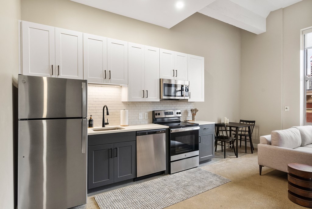 a kitchen with stainless steel appliances and white cabinets at Textile Apartments, Cincinnati, OH