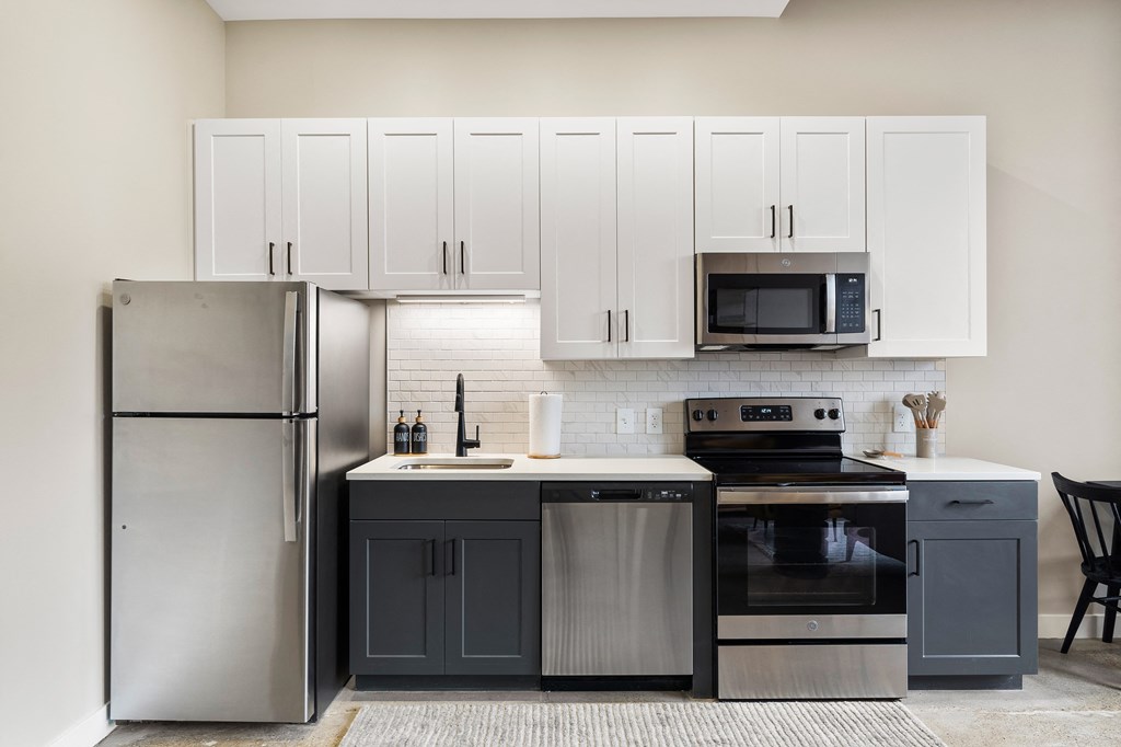 a kitchen with stainless steel appliances and white cabinets at Textile Apartments, Cincinnati, OH