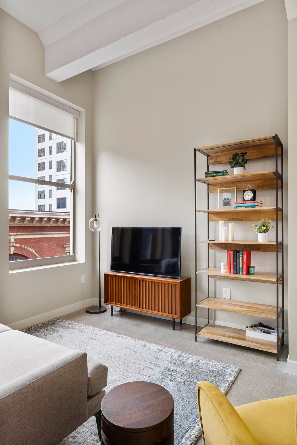 a living room with a couch and a television and a bookshelf at Textile Apartments, Cincinnati