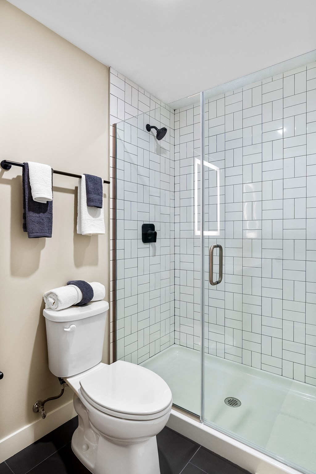 a white bathroom with a toilet and a shower at Textile Apartments, Ohio