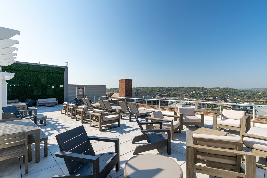 a roof top patio with tables and chairs and a view of the city at Textile Apartments, Cincinnati, Ohio
