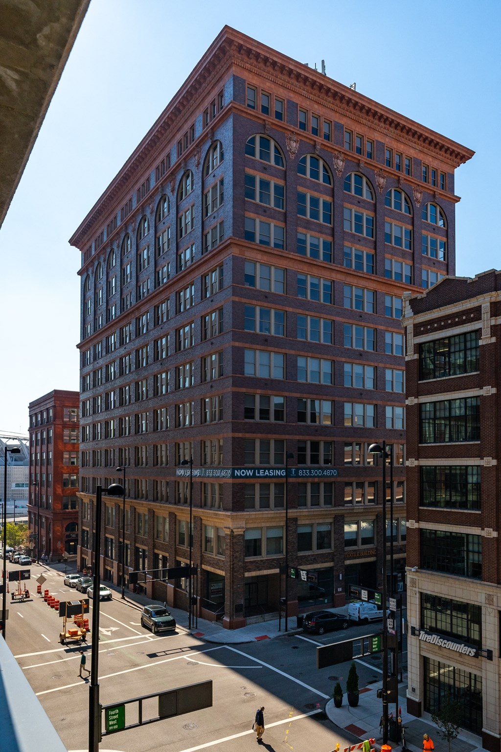 a tall brick building with a street in front of it at Textile Apartments, Cincinnati, OH