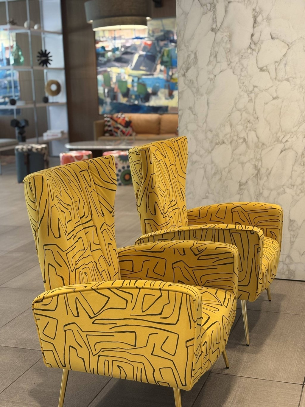 A row of yellow patterned chairs are lined up in a row.