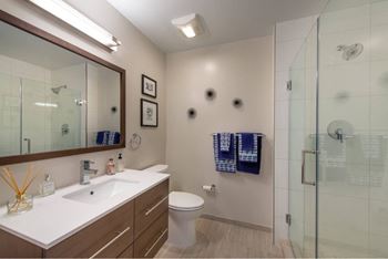 A bathroom with a sink, toilet, and shower.