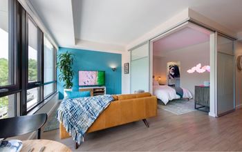 A bedroom with a bed covered in a blue and white blanket.