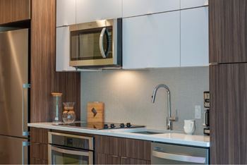 A modern kitchen with a stainless steel refrigerator and a microwave above the stove.