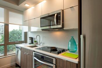 A modern kitchen with a stove top oven and microwave above it.