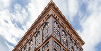 A tall brown building with many windows and a triangular top at Textile Apartments, Cincinnati, OH