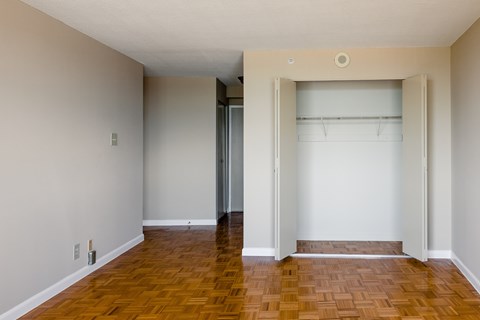 A room with a wooden floor and a white wall at Hampton Plaza Apartments, Towson