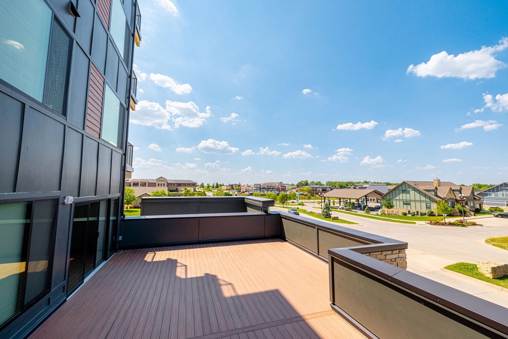 a balcony with a view of a city and a blue sky