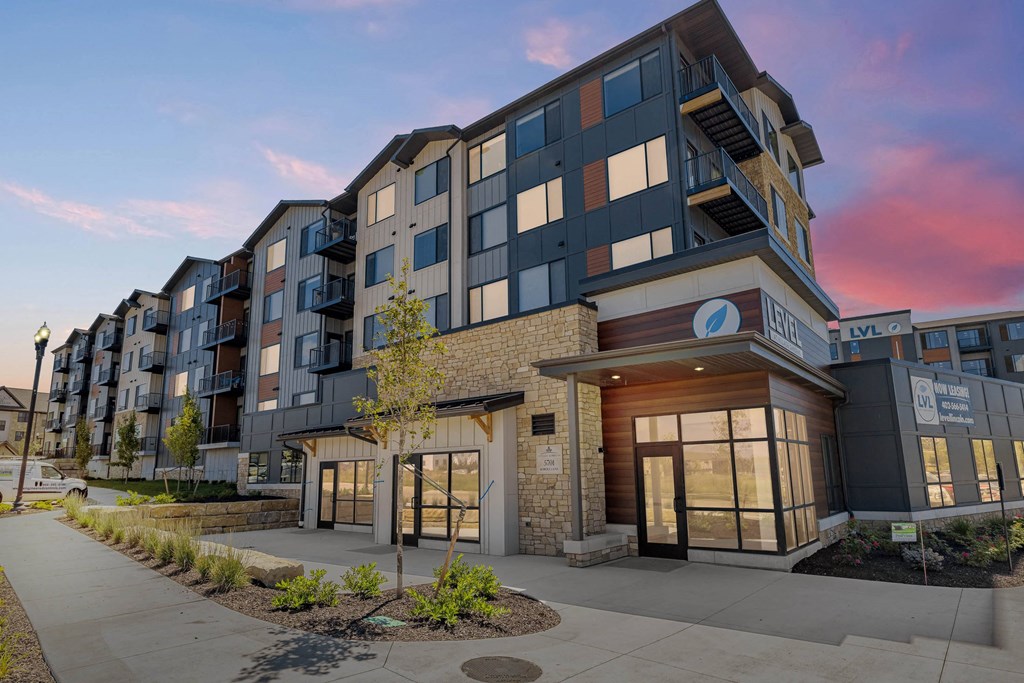 an exterior view of an apartment building at sunset