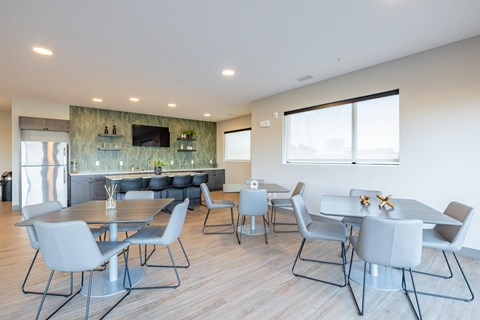 a dining room with tables and chairs and a kitchen